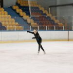 A young woman elegantly figure skating on an indoor ice rink, showcasing her skills. - Photo by Pavel Danilyuk on Pexels