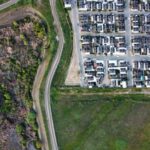 Drone view of a residential neighborhood alongside a natural landscape, showcasing urban and rural contrast. - Photo by Jorge Alvarado Gutierrez on Pexels